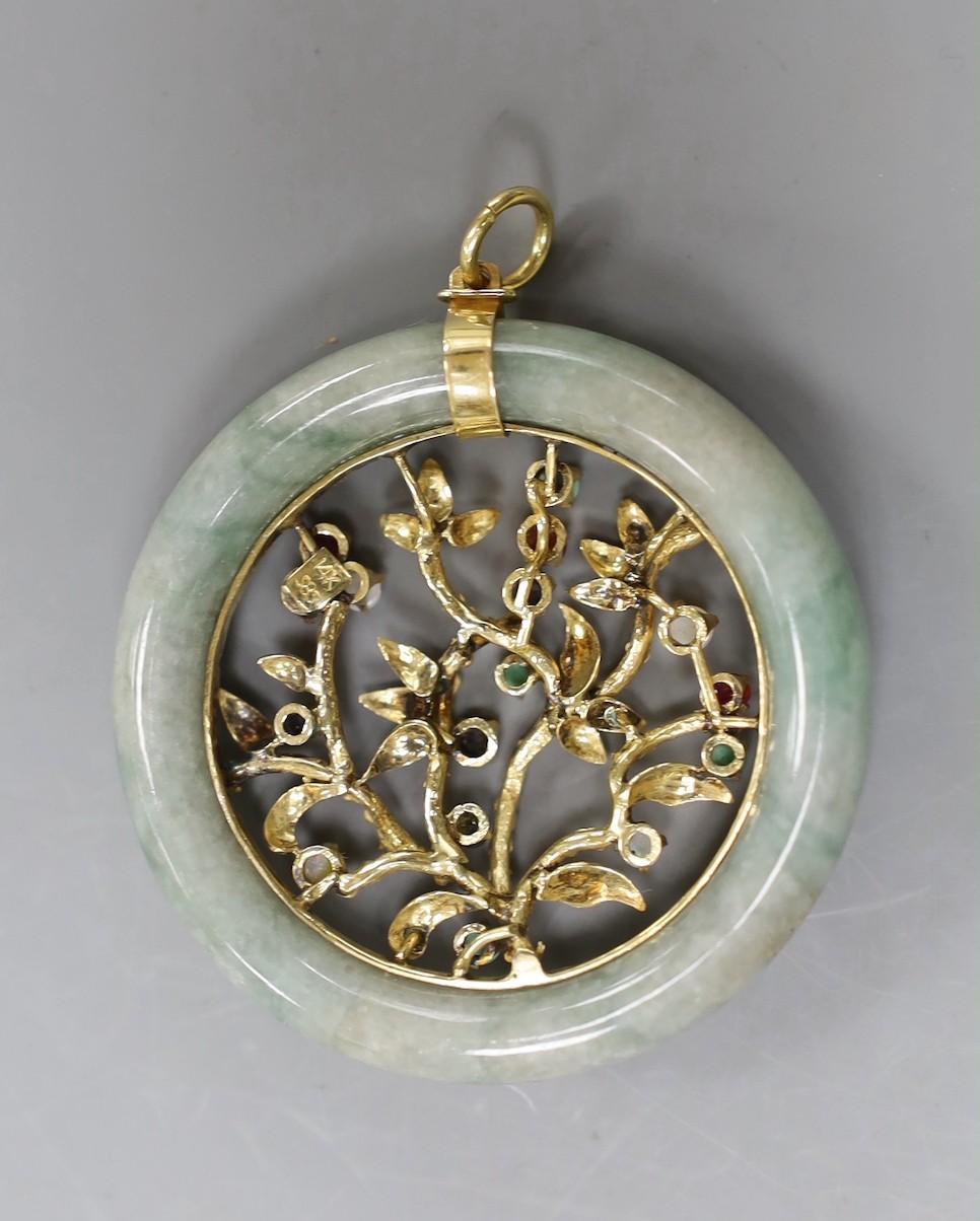 A 14k yellow metal and multi gem set circular jade pendant, diameter 51mm, gross weight 28.8 grams.